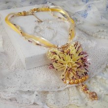 Pendentif La Petite Robe Jaune monté avec des rocailles de qualité couleur Jaune, Cerise et Rose, à laquelle s’ajoute des perles rondes nacrées en Cristal, perles et fleurs en plaqué Or